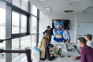 Image showing boss dresed as bear having fun with business people in trendy of