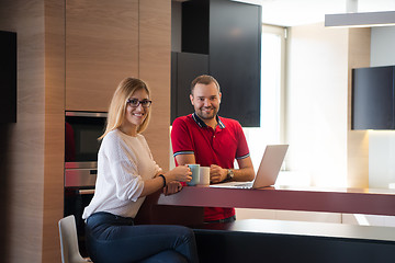 Image showing couple drinking coffee and using laptop at home