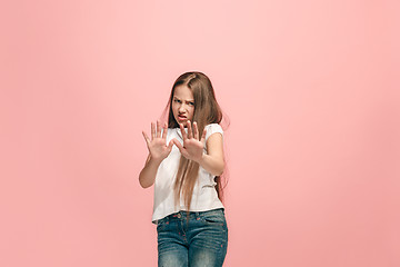 Image showing Doubtful pensive teen girl rejecting something against pink background