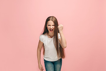 Image showing Portrait of angry teen girl on a pink studio background