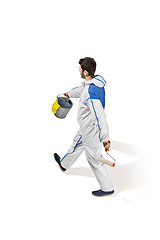 Image showing Young male decorator painting with a paint roller climbed a ladder isolated on white background.