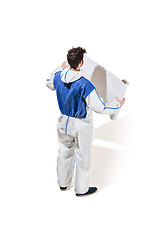 Image showing Young male decorator painting with a poster climbed a ladder isolated on white background.