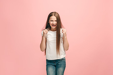 Image showing Portrait of angry teen girl on a pink studio background