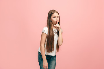 Image showing The young teen girl whispering a secret behind her hand over pink background