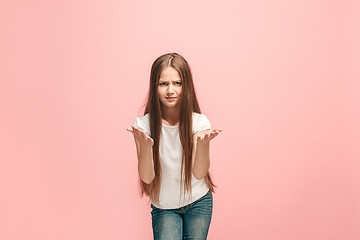 Image showing Beautiful female half-length portrait on pink studio backgroud. The young emotional teen girl