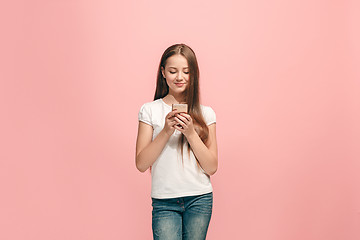 Image showing The happy teen girl standing and smiling against pink background.