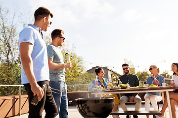 Image showing happy friends having bbq party on rooftop