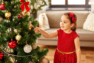 Image showing little girl decorating christmas tree at home