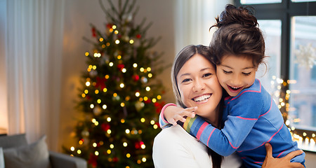 Image showing happy mother hugging her daughter on christmas