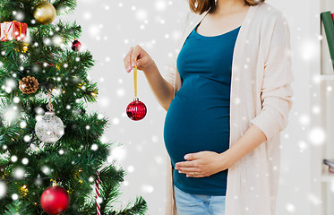 Image showing pregnant woman decorating christmas tree