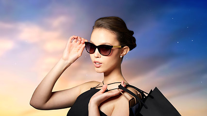 Image showing happy woman in black sunglasses with shopping bags