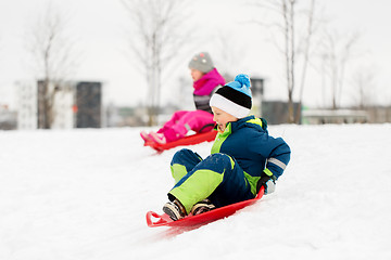 Image showing kids sliding on sleds down snow hill in winter