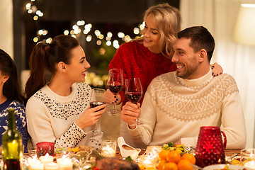 Image showing happy friends drinking red wine at christmas party