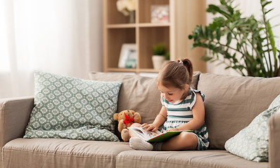 Image showing little girl reading book at home