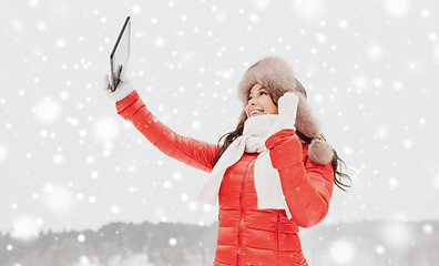 Image showing woman in winter fur hat with tablet pc outdoors