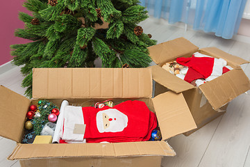 Image showing Boxes with Christmas decorations in front of an artificial Christmas tree