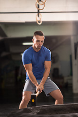 Image showing man workout with hammer and tractor tire