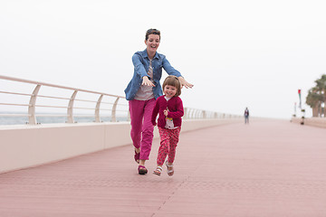 Image showing mother and cute little girl on the promenade by the sea