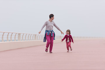 Image showing mother and cute little girl on the promenade by the sea