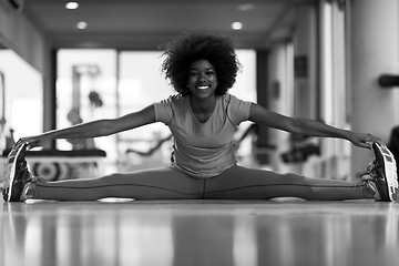 Image showing woman in a gym stretching and warming up before workout