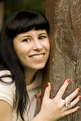 Image showing happy girl hiding behind a tree