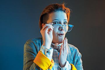 Image showing The young attractive woman looking suprised isolated on dark blue