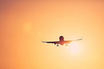 Image showing Airplane landing at sunset