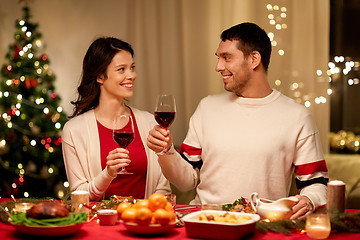 Image showing happy couple drinking red wine at christmas dinner