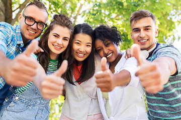 Image showing happy friends making thumbs up in park