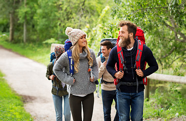 Image showing happy friends or travelers hiking with backpacks