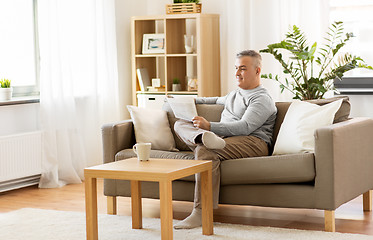 Image showing man reading newspaper at home