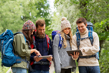 Image showing friends or travelers with backpacks and tablet pc