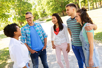 Image showing happy international friends talking in park