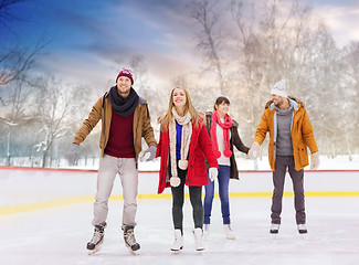 Image showing happy friends on outdoor skating rink