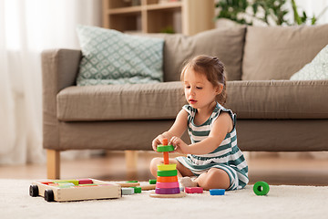 Image showing happy baby girl playing with toy blocks at home