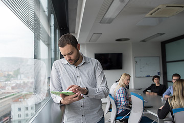 Image showing Businessman Using Tablet In Office Building by window