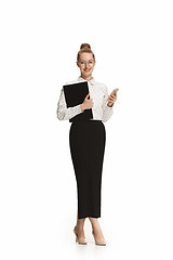 Image showing Full length portrait of a smiling female teacher holding a folder isolated against white background