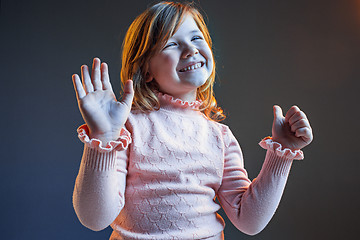 Image showing The happy teen girl standing and smiling against dark blue background.