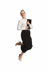 Image showing Full length portrait of a smiling female teacher holding a folder jumping against white background