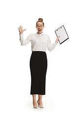 Image showing Full length portrait of a surprised female teacher holding a folder isolated against white background