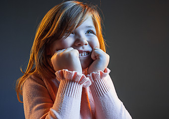 Image showing The happy teen girl standing and smiling against dark blue background.