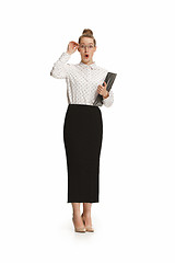 Image showing Full length portrait of a surprised female teacher holding a folder isolated against white background