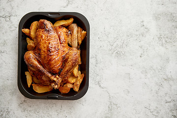 Image showing Roasted chicken or turkey with potatoes in black steel mold