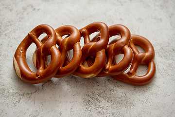 Image showing Row of fresh baked brown salty pretzel bread