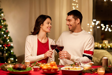Image showing happy couple drinking red wine at christmas dinner