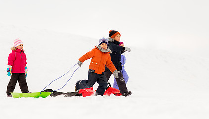 Image showing happy little kids with sleds in winter