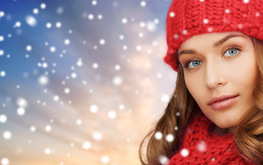 Image showing woman in red hat and scarf over snow background