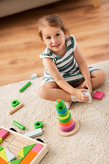 Image showing happy baby girl playing with toy blocks at home
