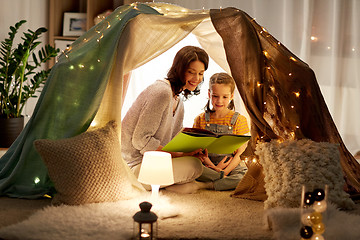 Image showing happy family reading book in kids tent at home