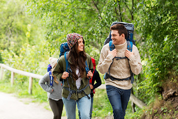 Image showing happy friends or travelers hiking with backpacks